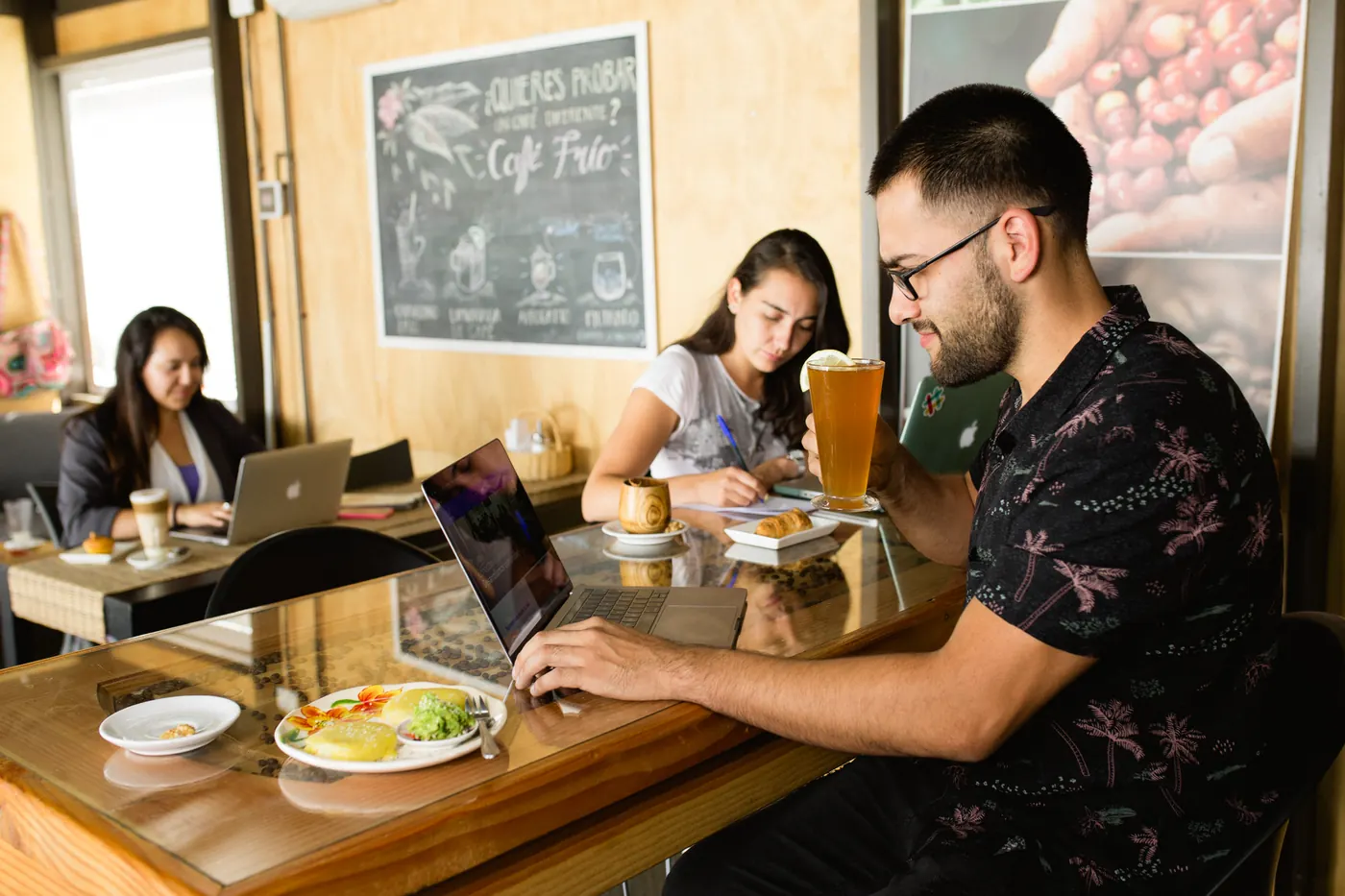 Amigos conversando en una cafetería con muro de madera.
