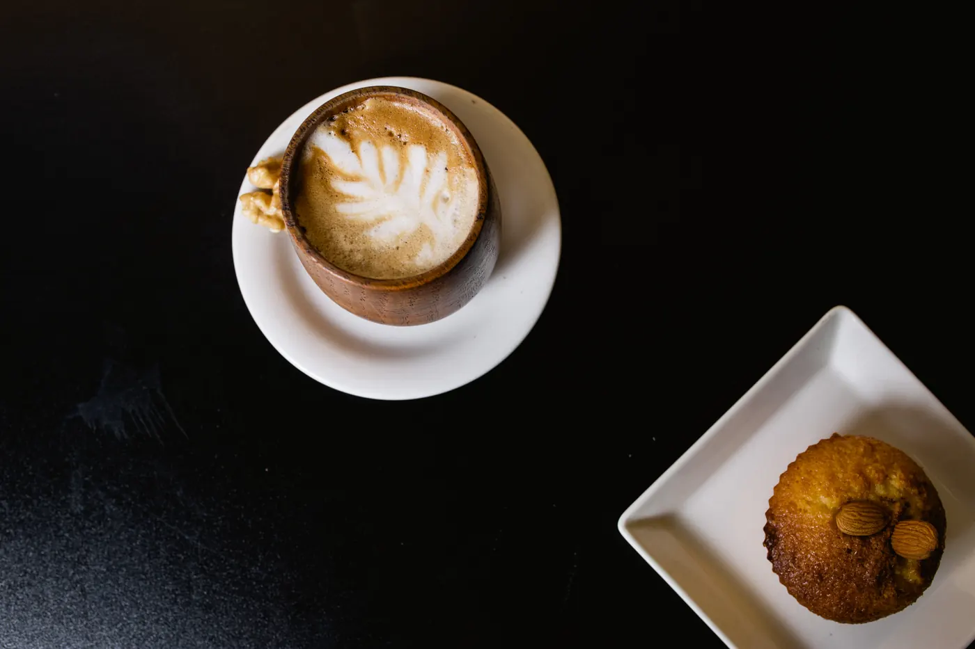 Café con arte latte sobre fondo negro.
