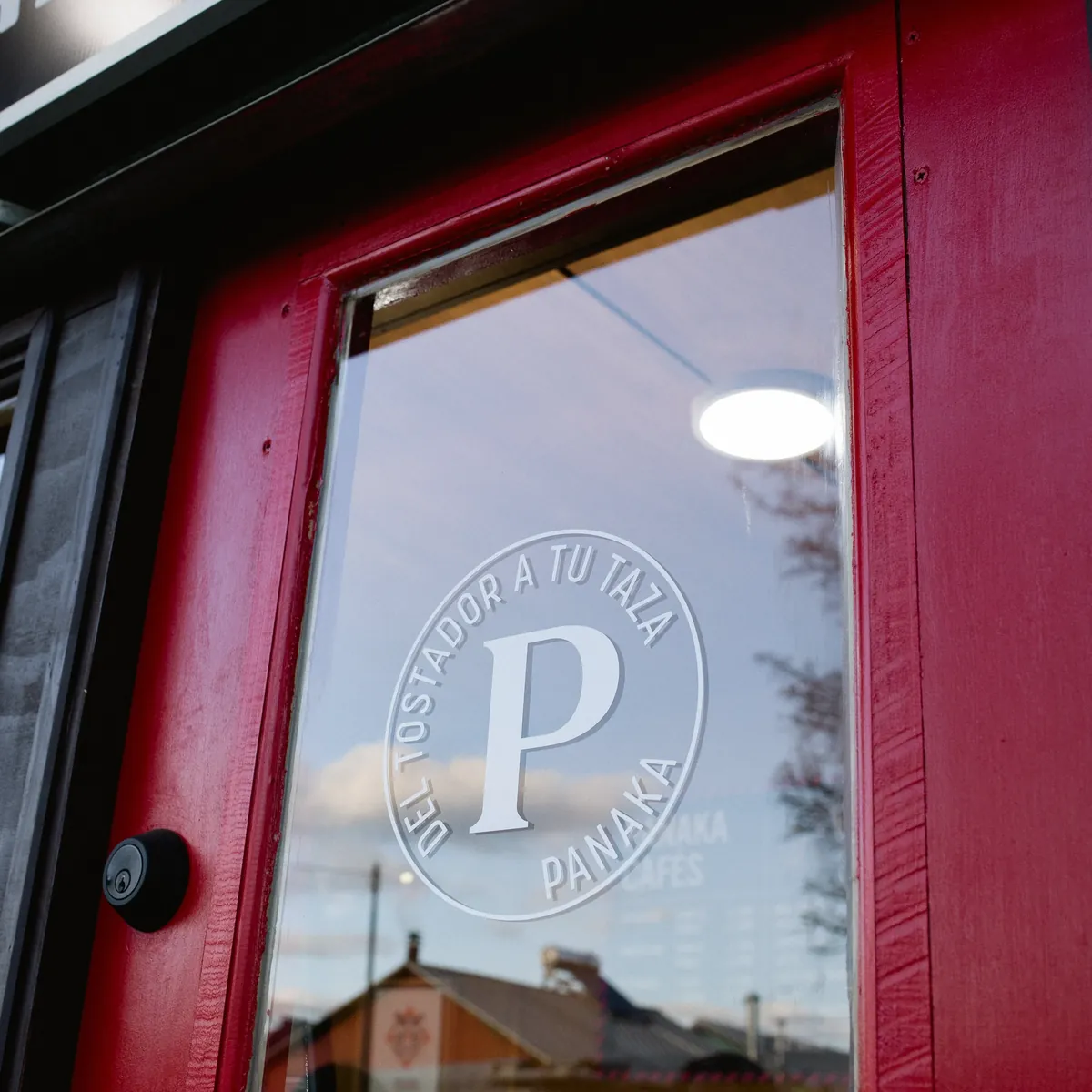 Puerta roja con vidrio y el logo de Panaka.