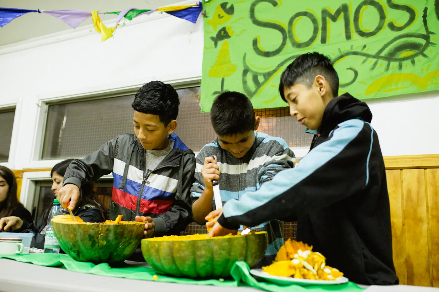 Niños preparando sopa de zapallo en un taller comunitario.