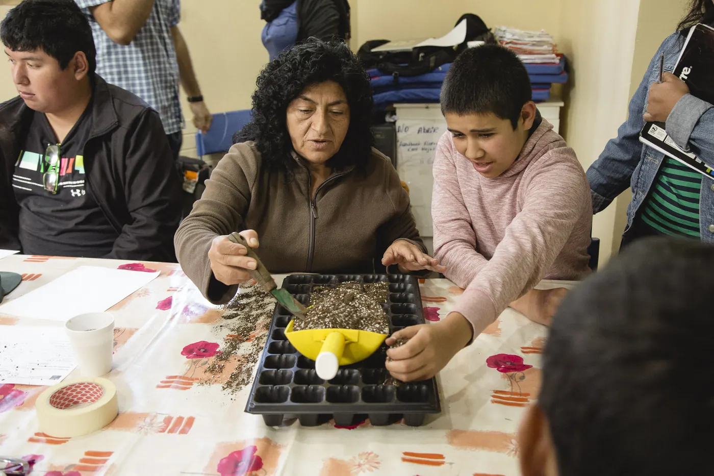 Personas sembrando almácigos en un taller.