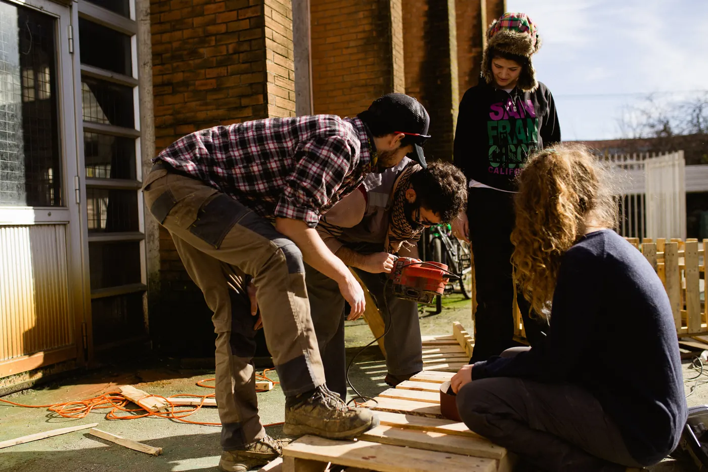 Voluntarios construyendo un huerto con pallets.